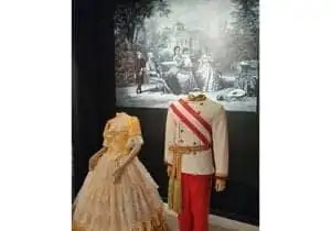 Klasszikus kori férfi portréja, fehérre púderezett hajjal, fehér szegélyű vörös kabátban. Enyhén mosolyog, és közvetlenül a nézőre néz.