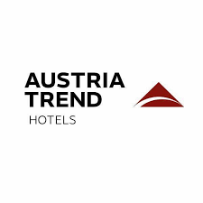 Logo der Austria Trend Hotels mit schwarzem Text auf wei&szlig;em Hintergrund. Neben dem Text befindet sich eine stilisierte rote Dreiecksform mit einem geschwungenen Ausschnitt.