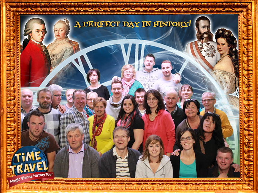 Eine Gruppe von Menschen posiert gemeinsam vor einer Kulisse mit einer großen Uhr, historischen Persönlichkeiten und dem Schriftzug „A PERFECT DAY IN HISTORY!“ in einem goldenen Rahmen. In der Ecke ist das Logo der „TIME TRAVEL Magic Vienna History Tour“ zu sehen.